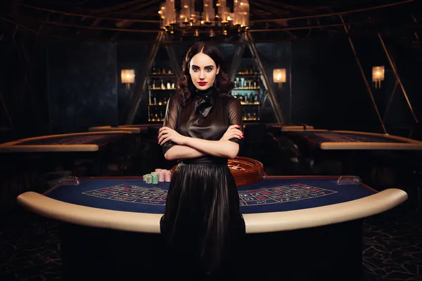 Uma mulher em um vestido verde luxuoso ao lado de uma roleta ornamentada, capturando o clima sofisticado do BBB22.